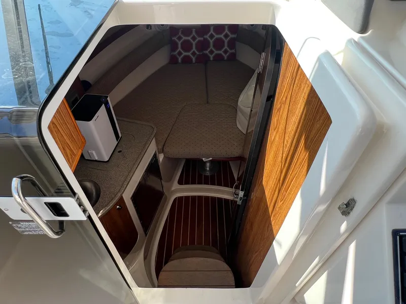 Slide: The Image of 2007 Pursuit OS 285 Offshore cabin interior with wood accents and cozy seating. - 14