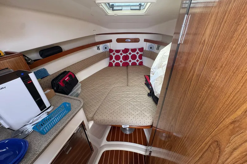 Slide: The Image of Cozy cabin interior of 2007 Pursuit OS 285 Offshore boat with bed and kitchenette. - 15