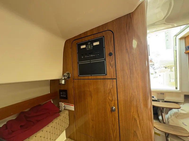 Slide: The Image of 2007 Pursuit OS 285 Offshore cabin interior with wood paneling and control panel. - 16