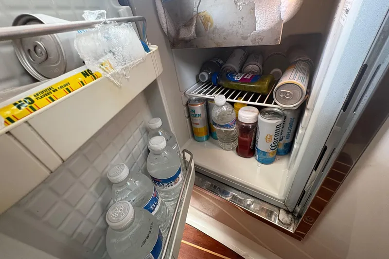 Slide: The Image of Refrigerator stocked with drinks and condiments on a 2007 Pursuit OS 285 Offshore boat. - 18