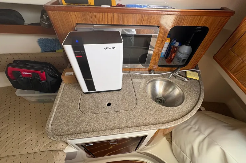 Slide: The Image of Compact kitchen area in a 2007 Pursuit OS 285 Offshore boat with sink and appliances. - 24