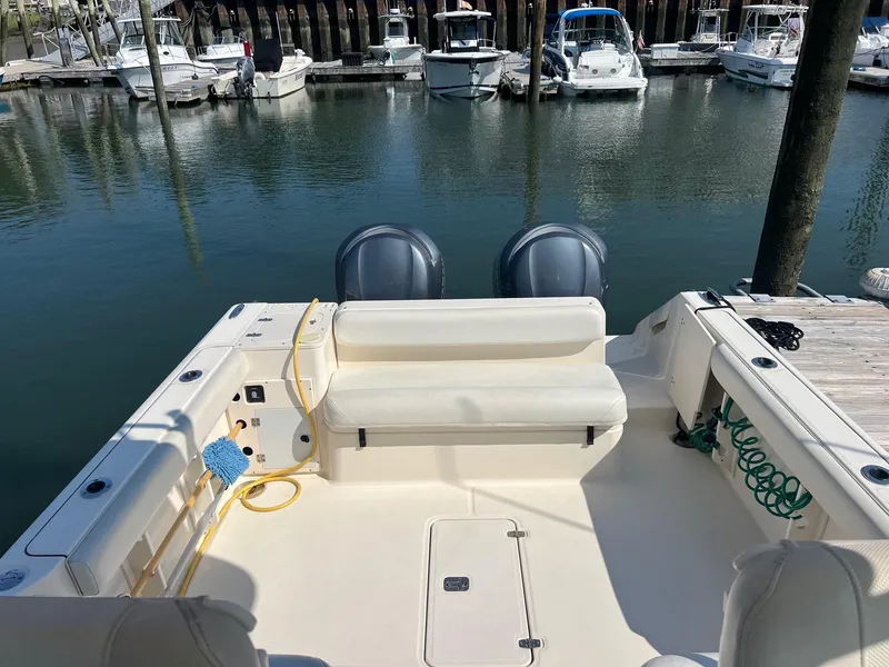 Slide: The Image of 2007 Pursuit OS 285 Offshore boat docked, featuring dual engines and spacious seating area. - 5