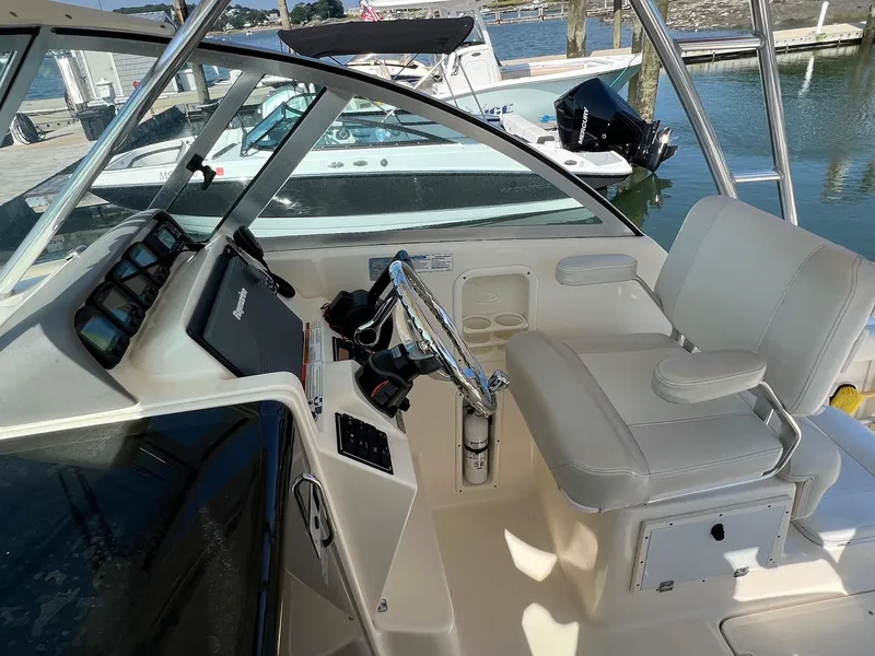 Slide: The Image of 2007 Pursuit OS 285 Offshore boat cockpit with steering wheel and white captain's chair. - 7