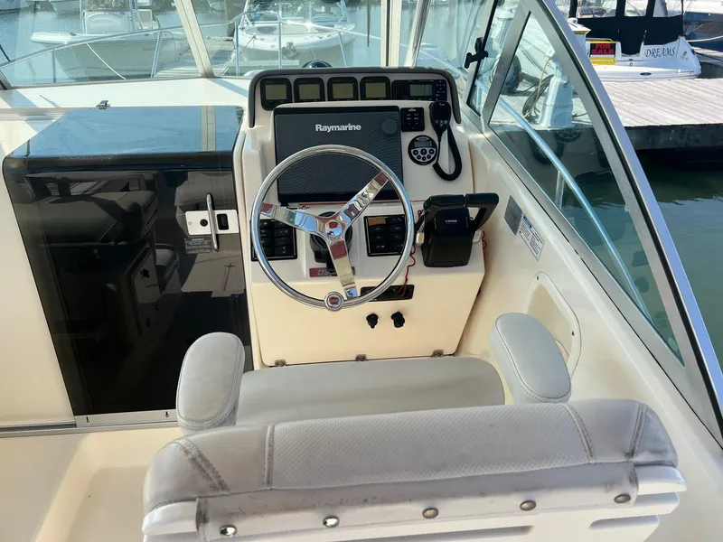 Slide: The Image of 2007 Pursuit OS 285 Offshore boat helm with steering wheel and navigation equipment. - 8