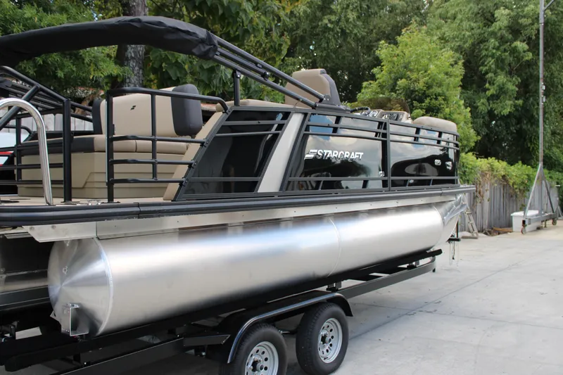 Slide: The Image of 2026 Starcraft EXS 1 Q DH pontoon boat on trailer, featuring sleek design and comfortable seating. - 5