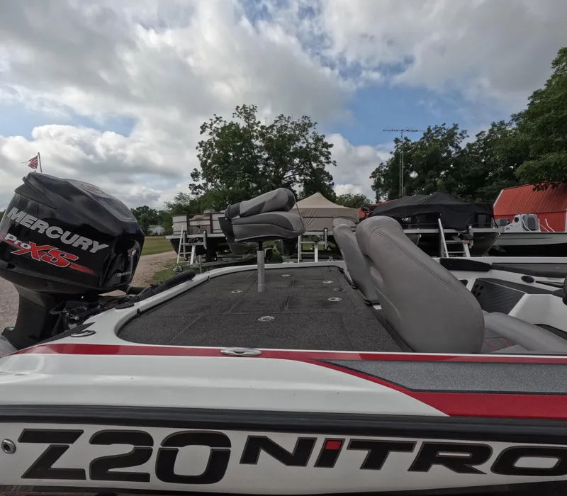 Slide: The Image of 2016 Nitro Z20 boat with Mercury Pro XS engine, parked outdoors under cloudy sky. - 11