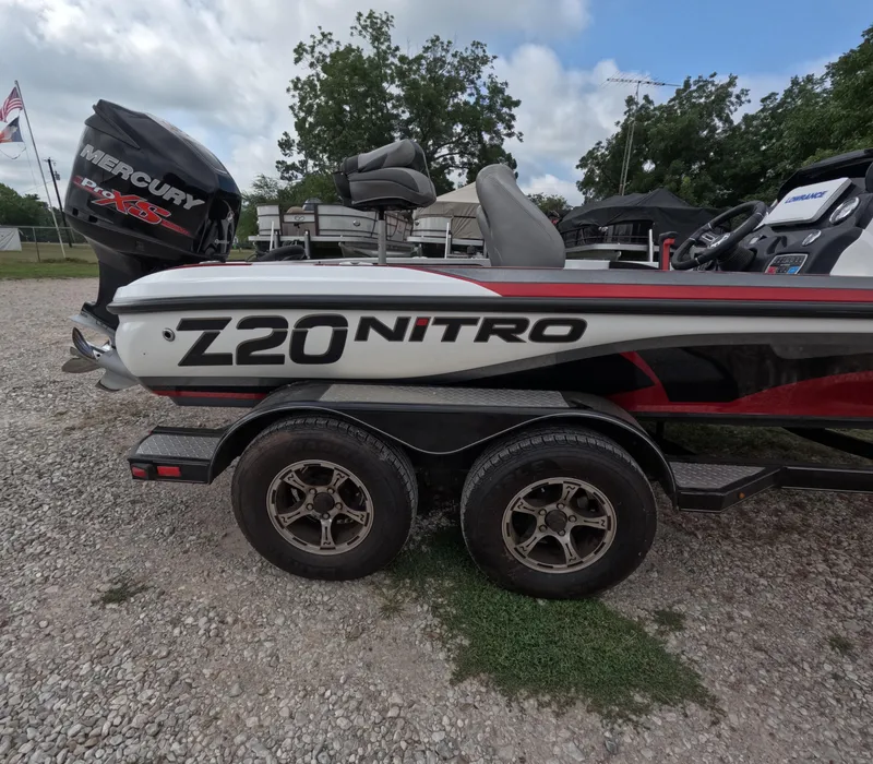 Slide: The Image of 2016 Nitro Z20 boat on trailer with Mercury engine, parked outdoors. - 14