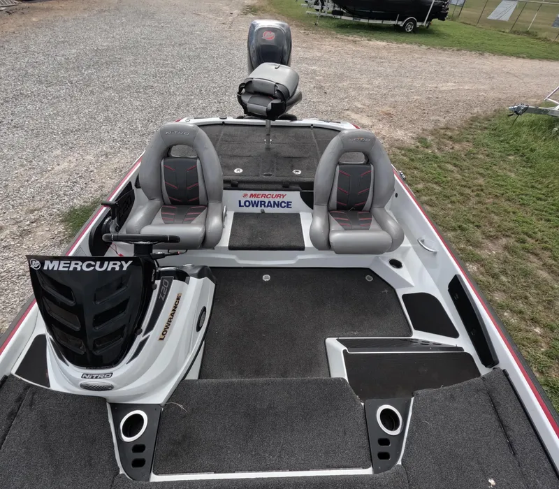 Slide: The Image of 2016 Nitro Z20 boat interior with Mercury engine and Lowrance equipment, parked on gravel. - 8