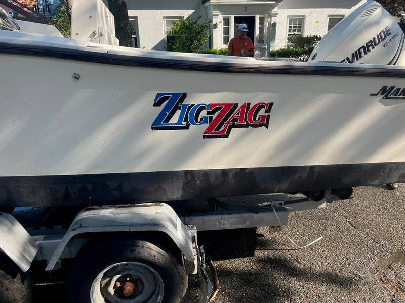 Slide: The Image of 1989 Mako 210 WA boat named "Zig Zag" on trailer, parked outdoors. - 14