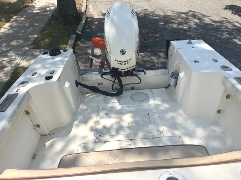Slide: The Image of 1989 Mako 210 WA boat with Evinrude motor, parked on street. - 15
