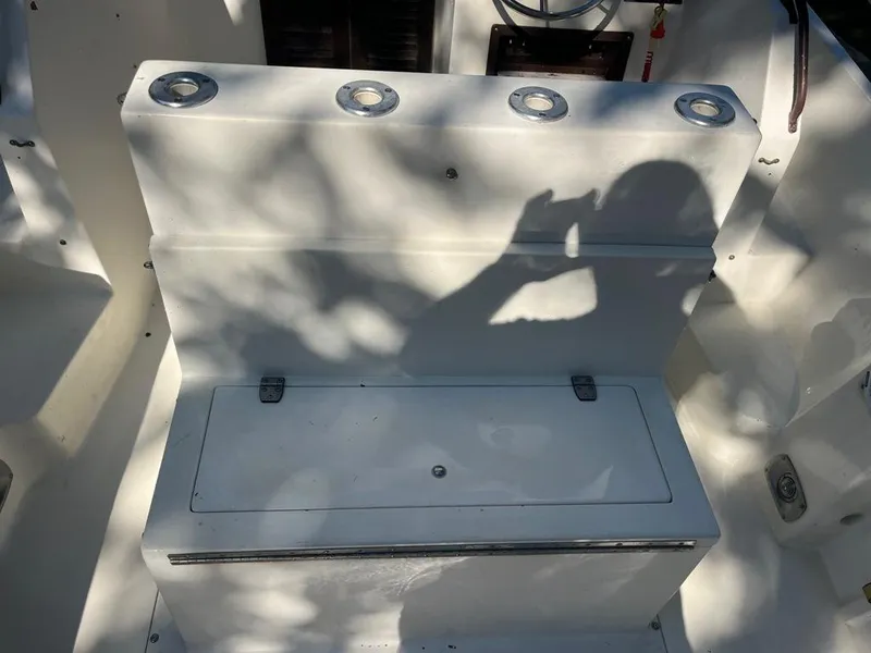 Slide: The Image of 1989 Mako 210 WA boat interior with rod holders and storage compartment. - 17