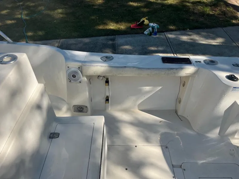 Slide: The Image of 1989 Mako 210 WA boat interior, featuring clean white seating and deck area. - 18