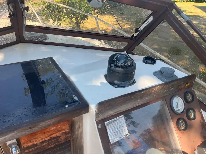 Slide: The Image of 1989 Mako 210 WA boat dashboard with compass and gauges, under clear canopy. - 20