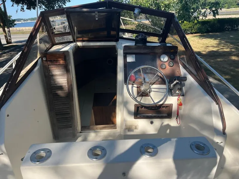 Slide: The Image of 1989 Mako 210 WA boat cockpit with steering wheel and control panel. - 23