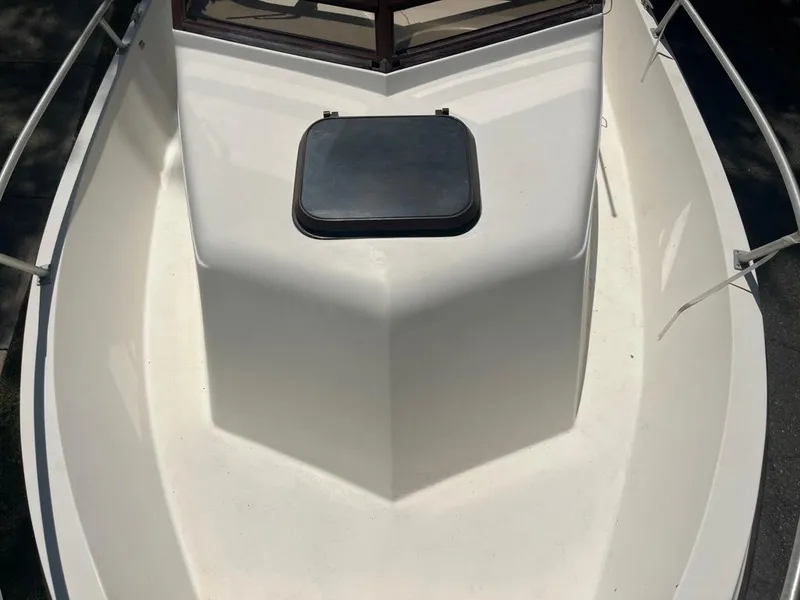 Slide: The Image of 1989 Mako 210 WA boat deck with hatch, white surface, and railing. - 28