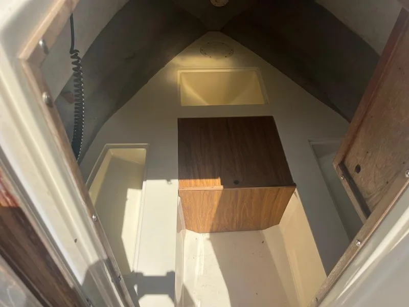 Slide: The Image of Interior cabin of a 1989 Mako 210 WA boat, featuring wood paneling and storage compartments. - 35