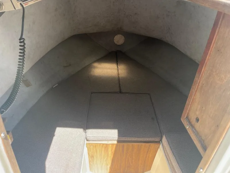 Slide: The Image of Interior cabin of a 1989 Mako 210 WA boat, featuring cushioned seating. - 36