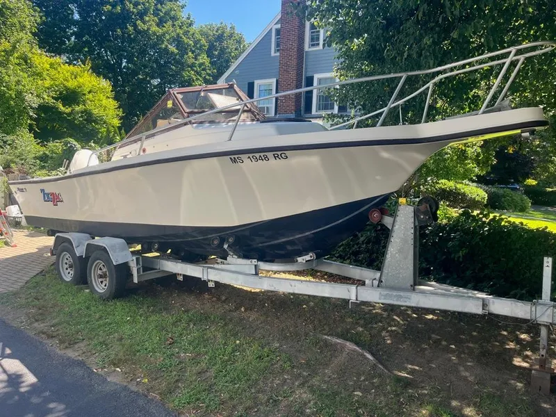 Slide: The Image of 1989 Mako 210 WA boat on trailer, parked in a residential yard. - 4