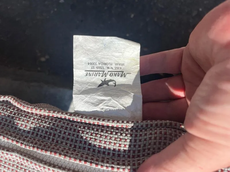 Slide: The Image of Label on fabric with "Mako Marine" logo, Miami address, and hand holding it. - 40