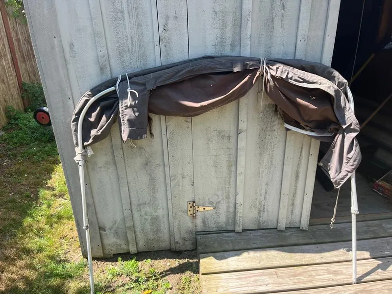Slide: The Image of Folded boat canopy leaning against a wooden shed, Mako 210 WA, 1989 model. - 41