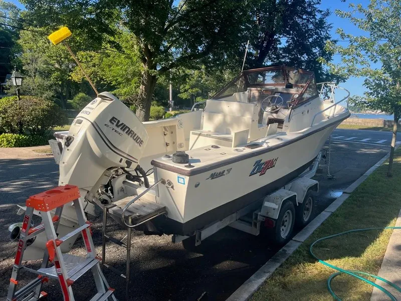 Slide: The Image of 1989 Mako 210 WA boat on trailer, parked on street, with Evinrude outboard motor. - 5