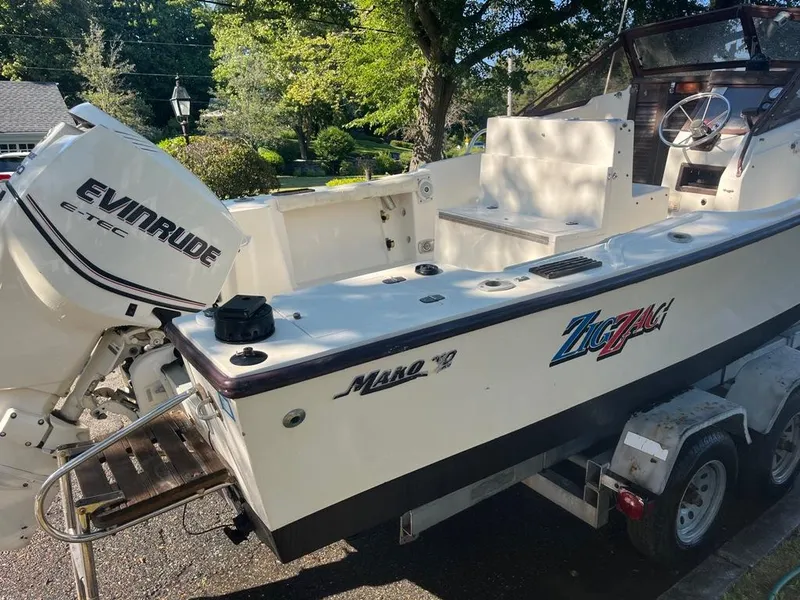 Slide: The Image of 1989 Mako 210 WA boat with Evinrude E-TEC engine on trailer, parked outdoors. - 9