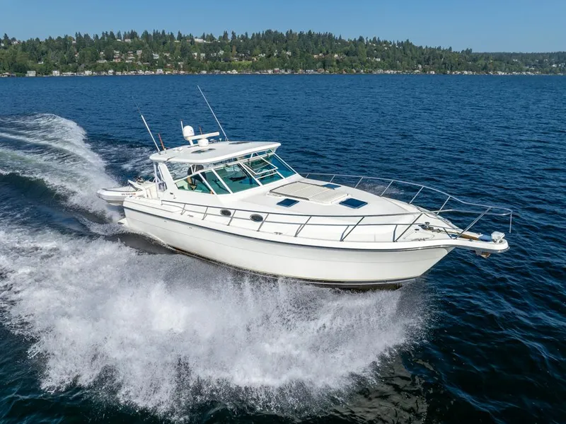 Slide: The Image of 2001 Tiara Sport 4000 EXPRESS cruising on a scenic lake with forested shoreline. - 0