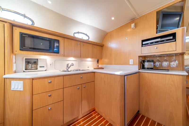 Slide: The Image of Luxurious 2001 Tiara Sport 4000 EXPRESS yacht kitchen with modern amenities and wood cabinetry. - 14