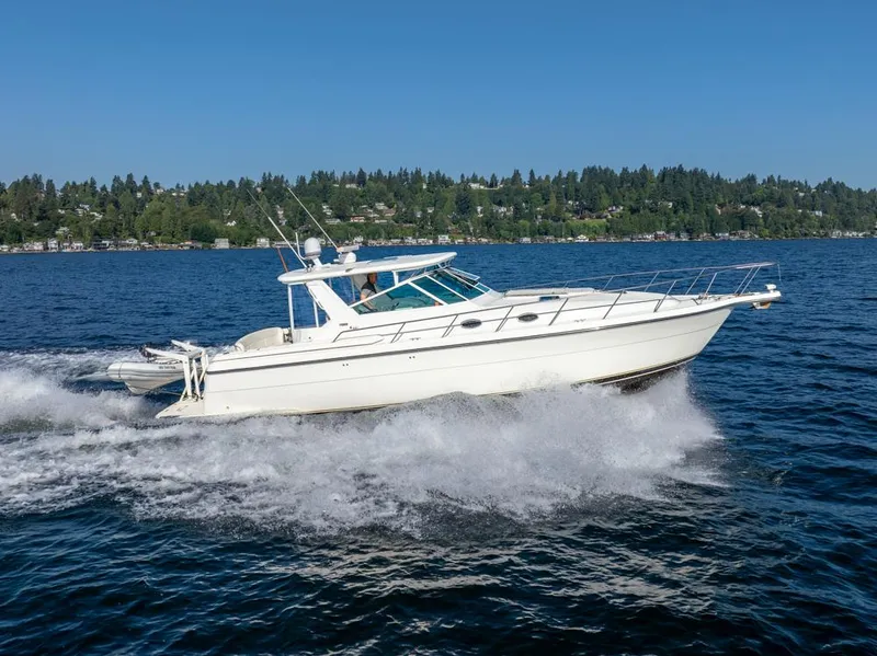Slide: The Image of 2001 Tiara Sport 4000 EXPRESS cruising on a lake with forested shoreline. - 2