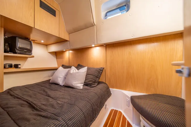 Slide: The Image of Cozy cabin interior of 2001 Tiara Sport 4000 EXPRESS with bed, TV, and wooden accents. - 21