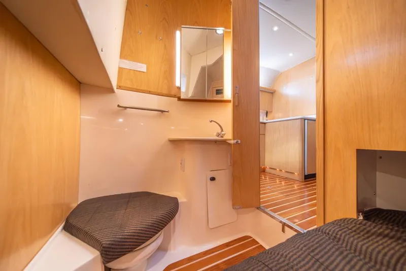 Slide: The Image of Interior of 2001 Tiara Sport 4000 EXPRESS yacht, featuring wooden cabinetry and compact bathroom. - 23