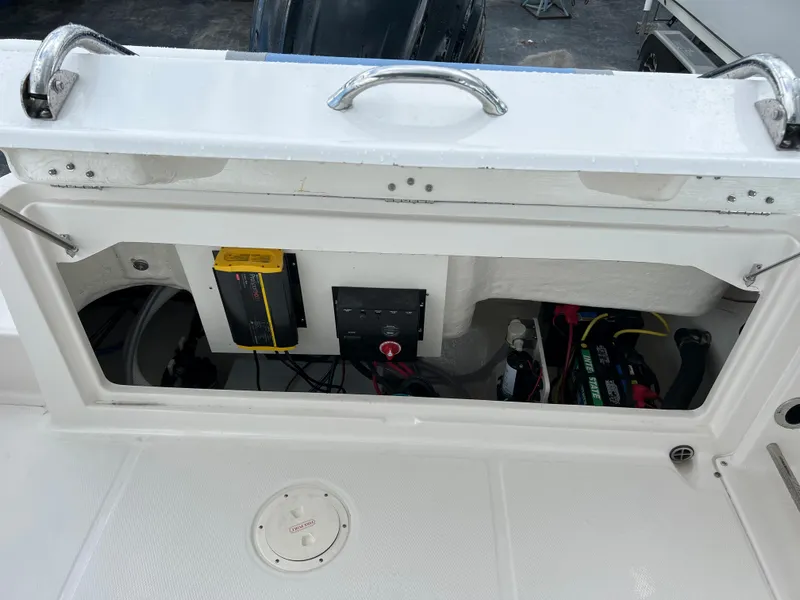 Slide: The Image of 2023 Robalo R222 Center Console boat storage compartment with electrical components. - 13