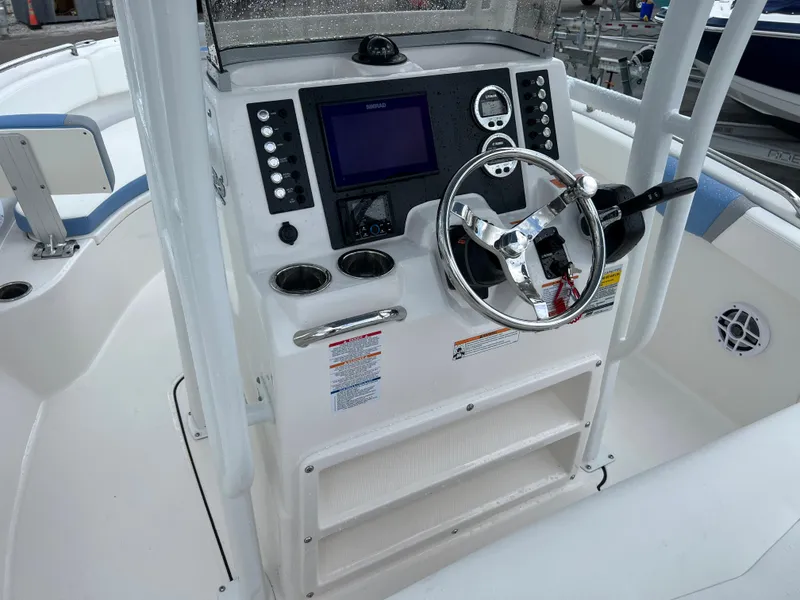 Slide: The Image of 2023 Robalo R222 Center Console boat dashboard with steering wheel and controls. - 6