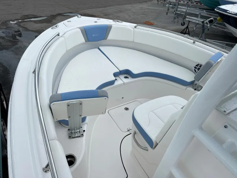 Slide: The Image of 2023 Robalo R222 Center Console boat with white and blue seating, docked outdoors. - 8