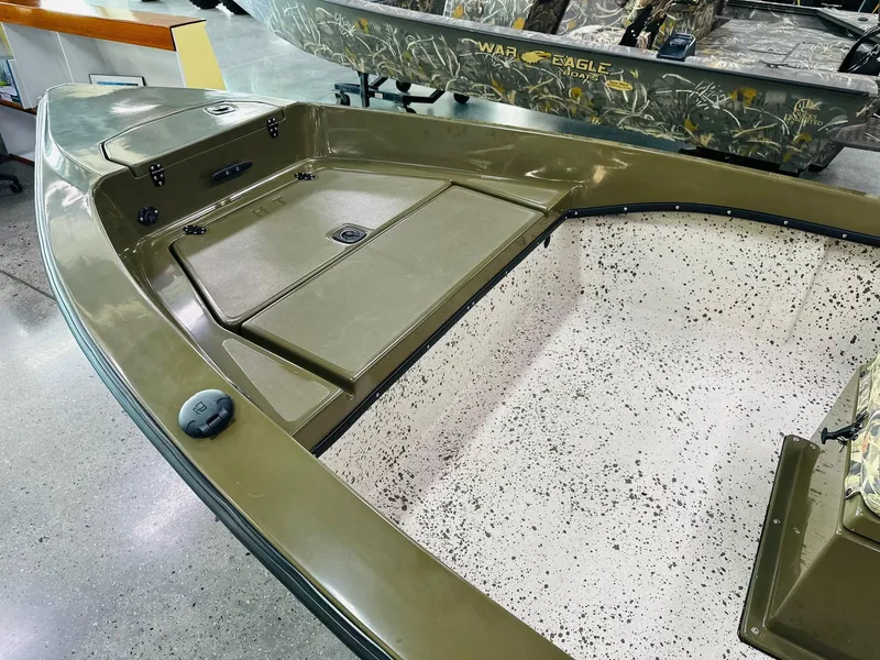 Slide: The Image of 2026 Mi Tide 1602 CC boat interior with olive green finish and speckled flooring. - 5