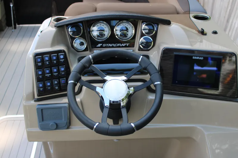 Slide: The Image of 2026 Starcraft CX 23 RL boat dashboard with steering wheel and control panel. - 10
