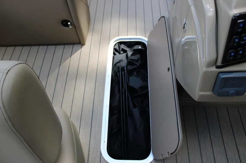 Slide: The Image of Open storage compartment on 2026 Starcraft CX 23 RL boat, revealing interior contents. - 14