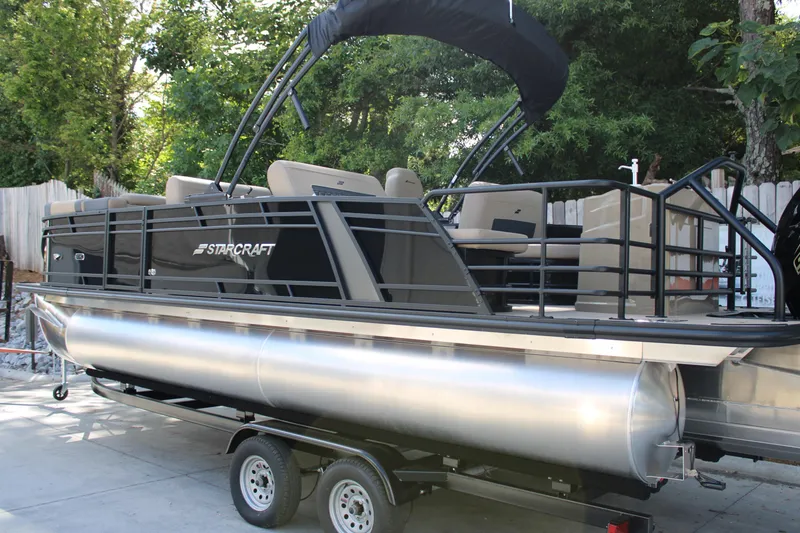 Slide: The Image of 2026 Starcraft CX 23 RL pontoon boat on trailer, parked outdoors. - 4