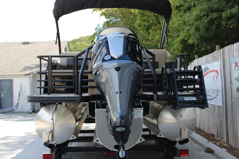 Slide: The Image of 2026 Starcraft CX 23 RL pontoon boat with powerful outboard motor, parked outdoors. - 5