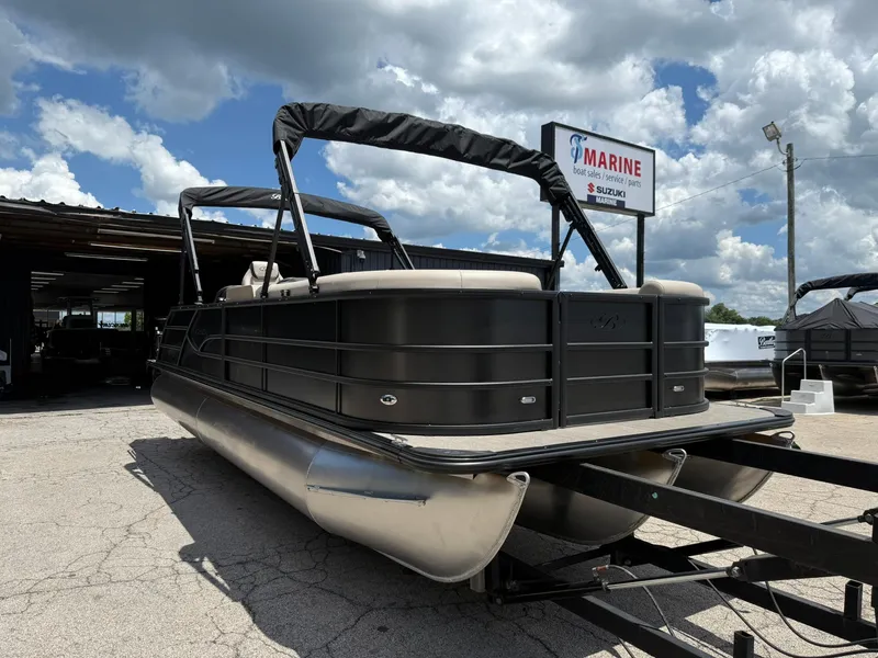 Slide: The Image of 2026 Bentley Pontoons Legacy 243 Swingback at a boat dealership under a cloudy sky. - 2