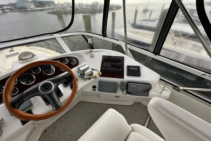 Slide: The Image of Cockpit view of 2002 Sea Ray 400 Sedan Bridge yacht with steering wheel and controls. - 16