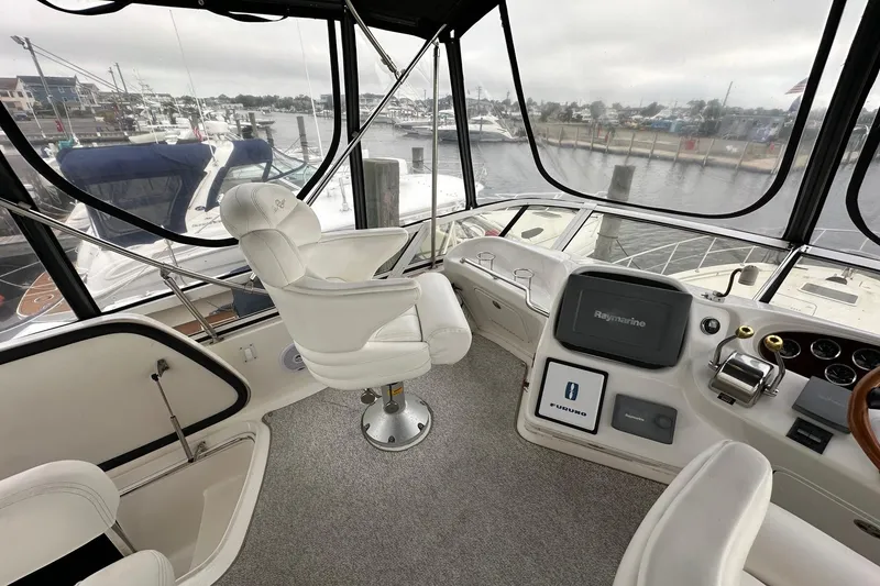 Slide: The Image of 2002 Sea Ray 400 Sedan Bridge helm with white captain's chair and navigation equipment. - 20