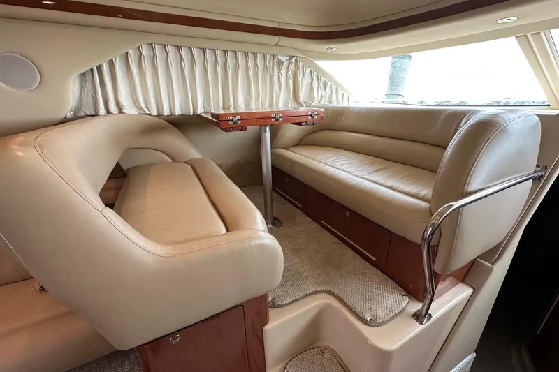Slide: The Image of Luxurious interior of 2002 Sea Ray 400 Sedan Bridge with beige leather seating and wooden table. - 22