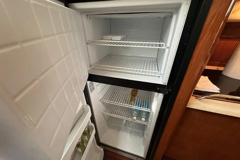 Slide: The Image of Refrigerator interior on 2002 Sea Ray 400 Sedan Bridge yacht, partially stocked with beverages. - 26