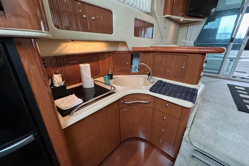 Slide: The Image of Luxurious 2002 Sea Ray 400 Sedan Bridge yacht kitchen with wood cabinetry and modern amenities. - 28