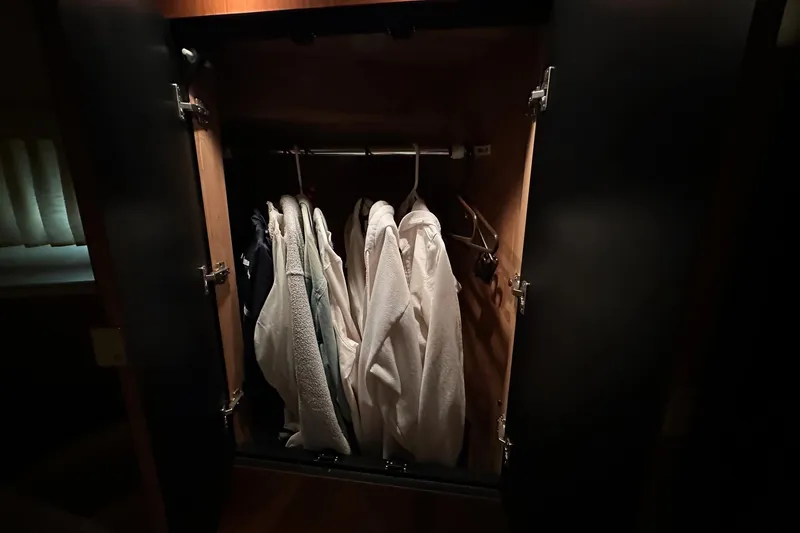 Slide: The Image of Open closet with hanging clothes inside a 2002 Sea Ray 400 Sedan Bridge yacht. - 35