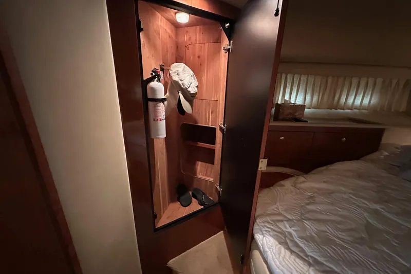 Slide: The Image of Interior of 2002 Sea Ray 400 Sedan Bridge showing closet with fire extinguisher and hat. - 36