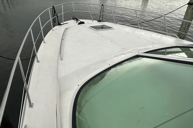 Slide: The Image of 2002 Sea Ray 400 Sedan Bridge yacht deck with railing, docked on calm water. - 37