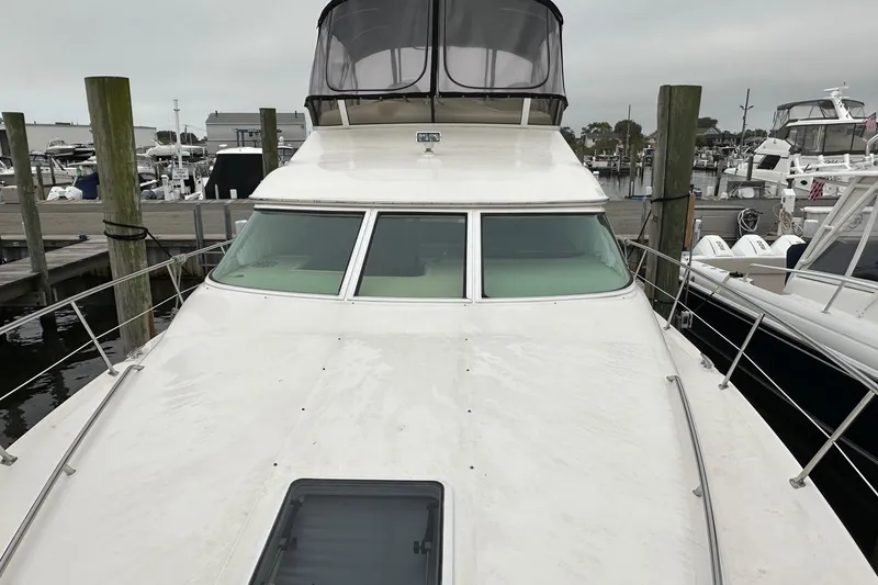 Slide: The Image of 2002 Sea Ray 400 Sedan Bridge yacht docked at a marina, showcasing its sleek design. - 40