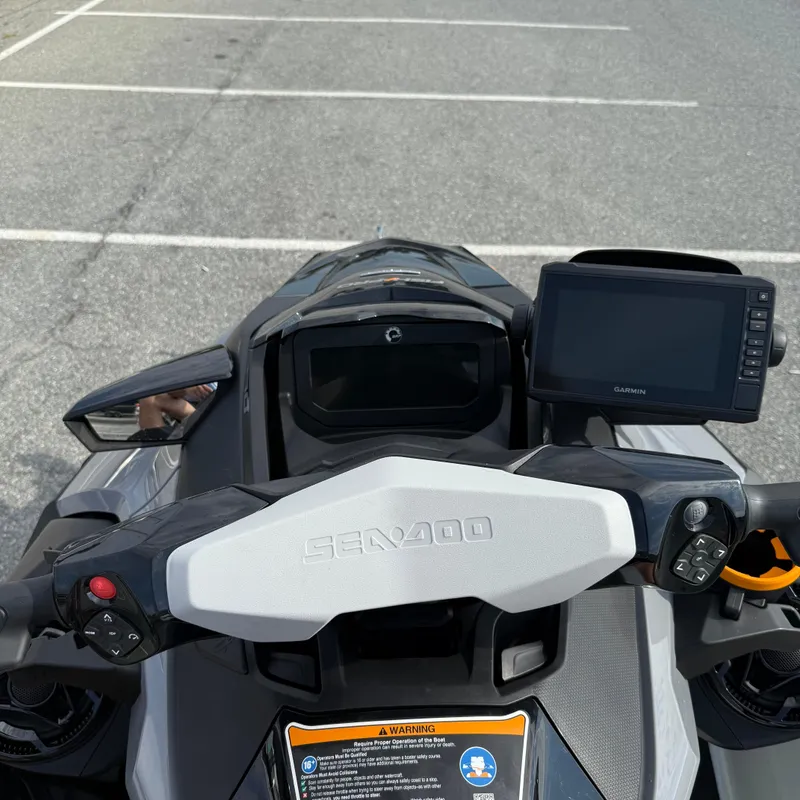 Slide: The Image of 2024 Sea-Doo Fishpro Trophy 170 dashboard with Garmin display in a parking lot. - 13